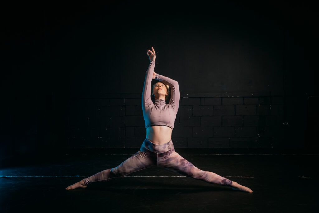 ICTheatre student doing the splits with her arms up
