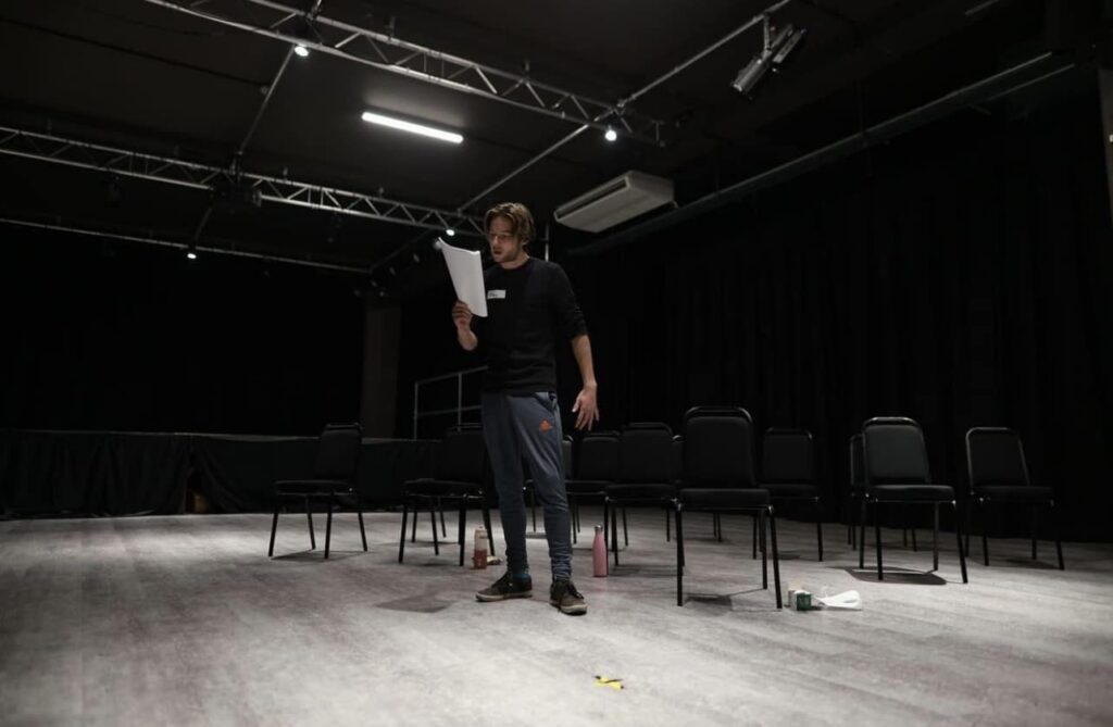 Finlay stand in studio reading script