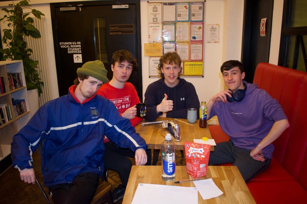 Sebastian sits in the ICTheatre common room with three friends