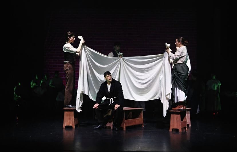 Sebastian portrays Scrooge sat on the end of his bed