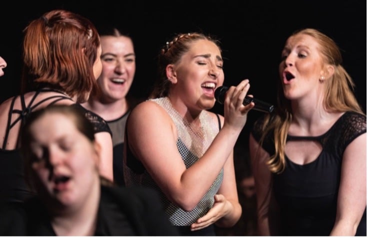 danielle sings into a microphone