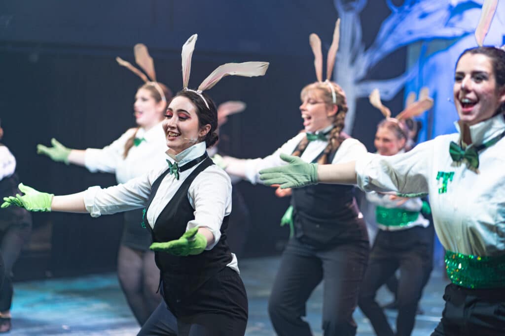 Performers College students performing on stage in costume for a performance