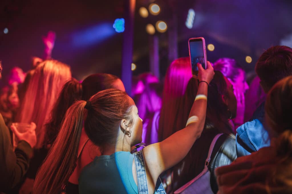 Student holding her phone recoding at an event