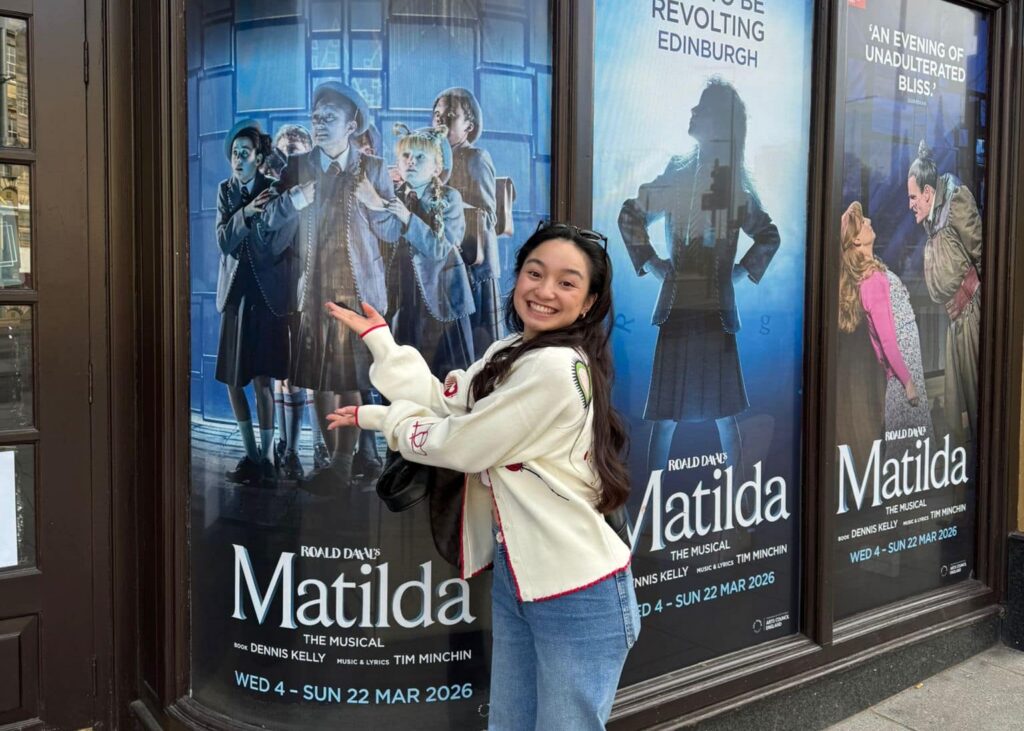 Nicole Manumbre outside the theatre with a show poster