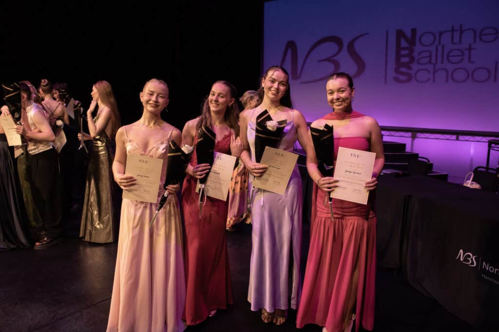 Four graduates on the stage of the NBS ceremony